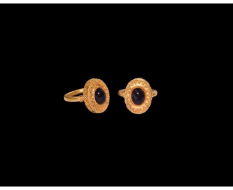 20th century AD. A Greek style gold-coloured metal ring comprising a substantial round-section hoop with wire coils to the sh