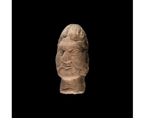 1st century AD or later. A ceramic head of a male with large almond-shaped eyes, wide flat nose, joined eyebrows, short beard