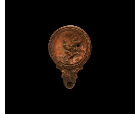 19th century AD. An antique or earlier Roman ceramic oil lamp in 2nd century AD style with round nozzle, volute scroll to eac