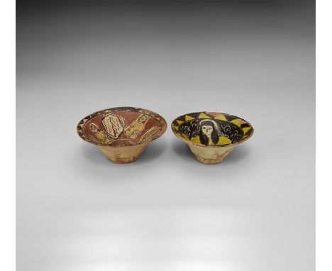 A pair of glazed ceramic bowls comprising: one with seated facing female holding a vessel; one with frieze of three squatting