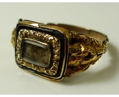 A Victorian mourning ring, the central rectangular cartouche set with plaited hair with enamelled black border, gold inner bo