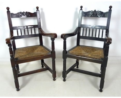 A late 19th century stained oak open armchair, carved crest to the top rail , drop in rush seats, ring turned front legs join