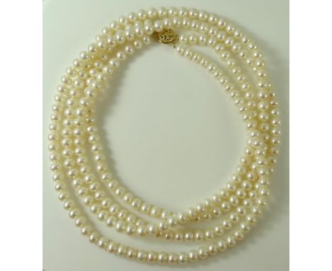 A double strand ivory pearl necklace with 9ct gold pierced floral clasp, the necklace formed of two hundred and fifty pearls,