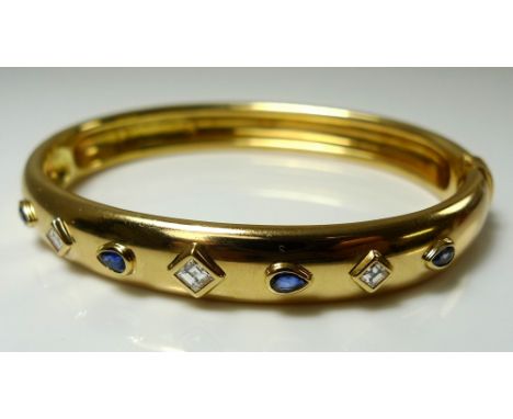 A Must de Cartier 18ct gold, diamond and sapphire hinged bangle, set with four pear cut sapphires interspersed with three squ