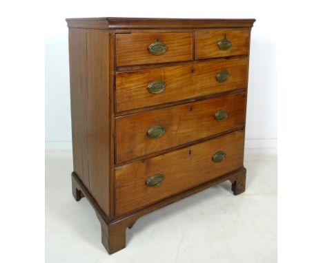 A George III mahogany chest of two short over three long graduating drawers, with brass oval plate handles, raised on bracket