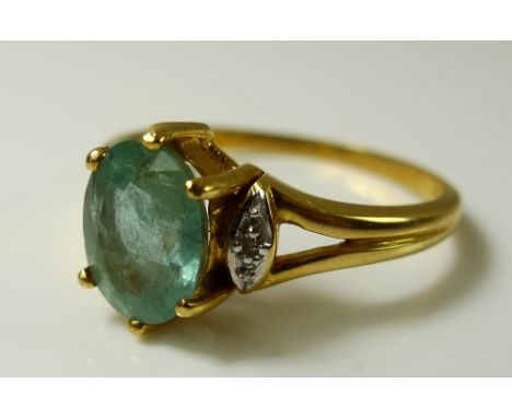 An 18ct gold, aquamarine and diamond dress ring, the central oval aquamarine of approximately 9 by 7 by 4.8mm, flanked by ill