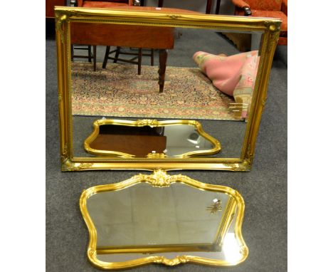 A large gilt framed mirror; another shaped and decorated in scrolling acanthus leaves (2)
