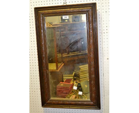 A mid 20th Century rectangular mirror, carved with scrolls
