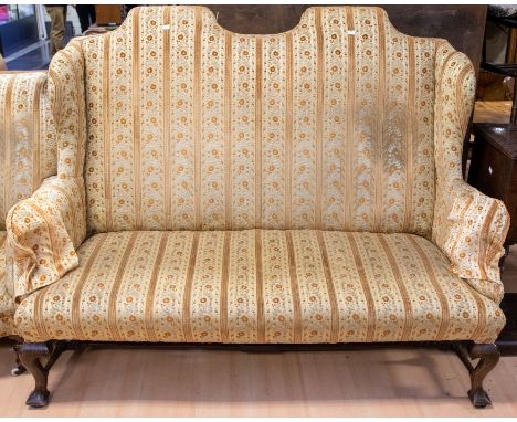 An early 20th Century two-seater sofa in with oak frame and legs and gold upholstery