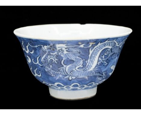 A Chinese blue and white wine cup, the interior painted with a four-claw dragon, further dragons to exterior, four character 