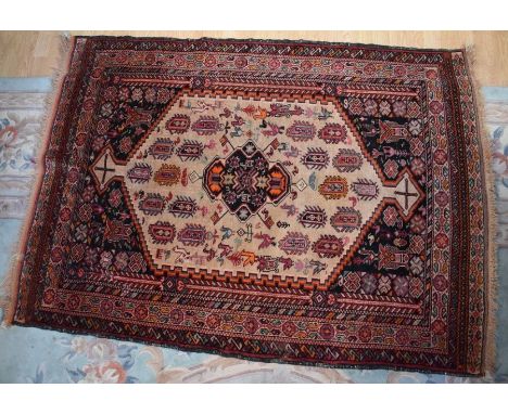 A hand-knotted Middle Eastern rug having motif borders and a geometric central panel with bird figures, torn and repaired, 16