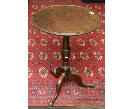 A George III mahogany tilt-top tripod table, the dished top above a turned tapered column, three cabriole legs with pad feet,