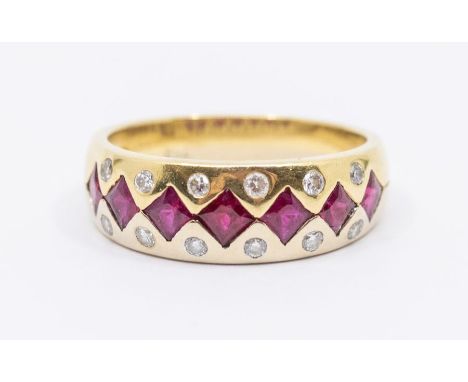 A ruby and diamond 18ct gold dress ring, comprising a central row of French cut rubies flush set with round brilliant cut dia
