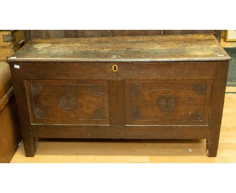 A late 17th Century oak plank chest, double panel front with folk art carved lunettes and mons, stiles, width 111cm