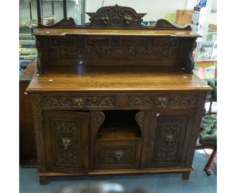 Late 19th Century oak carved large side board with two drawers over shelf and three cupboard doors carved with green man styl