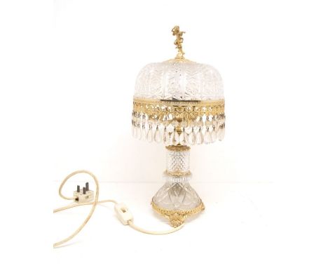 A pressed glass table lamp with spelter mounts and figural finial to top of shade.