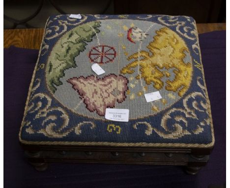An Edwardian cruel work footstool with four turned feet; the design depicts the globe, a compass and sailing ship