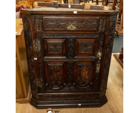 A late 18th Century dark wood, panel backed corner cabinet, heavily decorated, having a pencil inscription to Newstead Abbey 