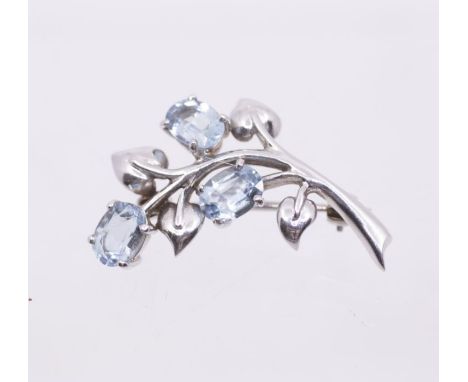 An aquamarine and 9ct white gold spray brooch, with foliate leaf decoration, set with oval claw set aquamarines, length appor