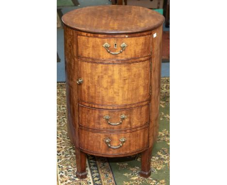 A George III mahogany oval commode cupboard, the slightly oversailing top above a single drawer, cupboard, and deep drawer wi