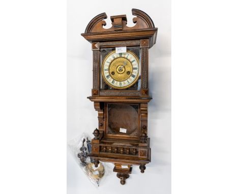 An Edwardian Vienna-style wall clock dated by retailers label Dec 17th 1935. Contained in a walnut stained case with decorati