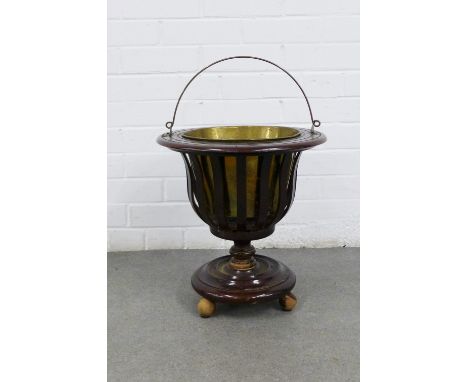 Mahogany circular basket planter with a brass insert and handle, on three bun feet, 39 x 40cm
