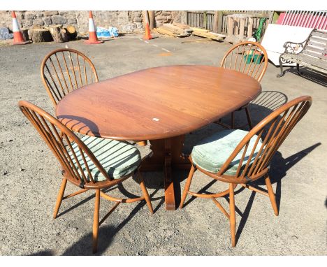 An Ercol extending circular dinning table and four chairs.