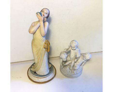 Two Figurines Cappa de Monte one a lady using a compact the other three bisque cherubs the lady signed 1982