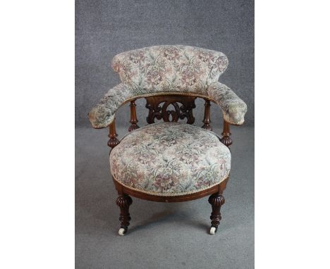A Victorian walnut armchair, upholstered in a tapestry fabric, with a pierced splat back, on lobed and turned legs. 