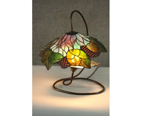 A Tiffany style stained glass table lamp, the shade with foliate design. H.48 W.40cm. 