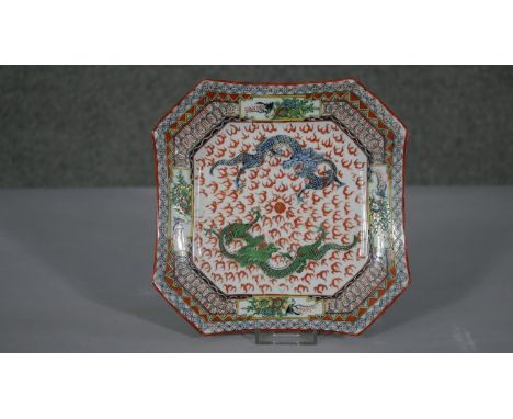 A 20th century Chinese hand painted porcelain octagonal plate. Decorated with two dragons chasing a pearl, birds and flowers.