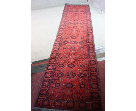 A red ground handmade Afghan Ankhoi runner. L.383 W.76cm. 