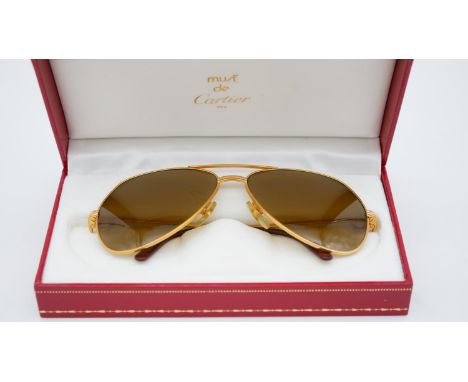 A red leather cased pair of vintage Must de Cartier bicolour gold plated 140 aviator sunglasses, accompanied by document wall