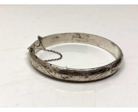 A sterling silver bangle with safety chain 