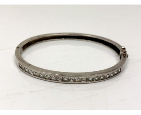 A silver bangle with channel set stones 