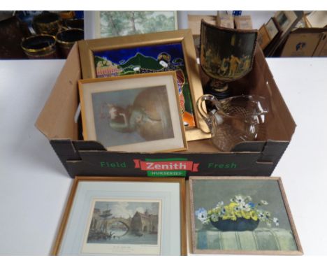 A box of assorted framed pictures, cut glass water jug, framed pottery tile, gilt table lamp 