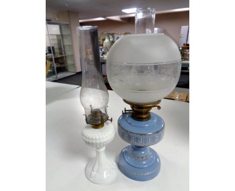 An antique Flash of Slough blue glass and brass oil lamp with chimney and shade together with a further oil lamp on white gla