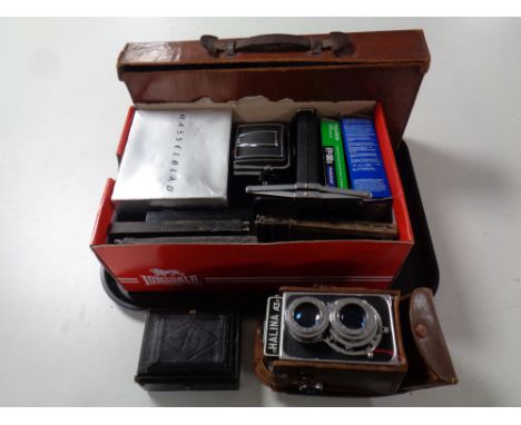 A tray containing cameras and camera equipment to include Halina camera in leather case, Hasselblad camera body, accessories 
