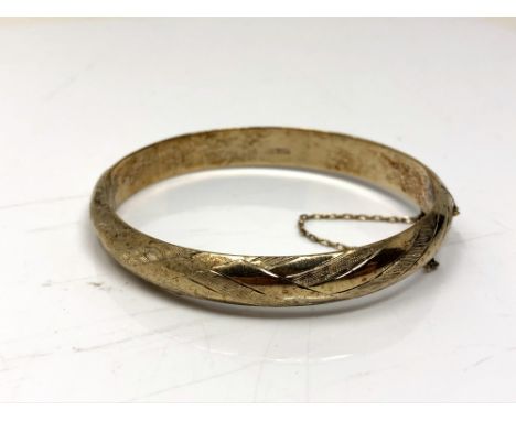 A rolled gold bangle with textured decoration 