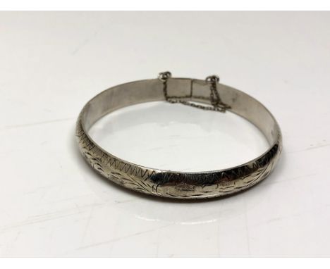 A sterling silver bangle with safety chain 