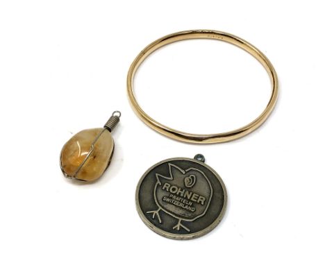 A gold plated bangle together with two pendants 