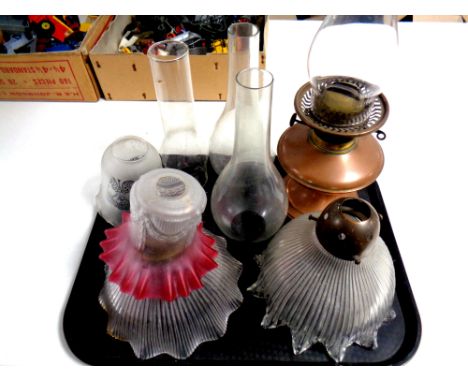 A tray of antique copper and brass oil lamp base with chimney together with three further oil lamp chimneys and four further 