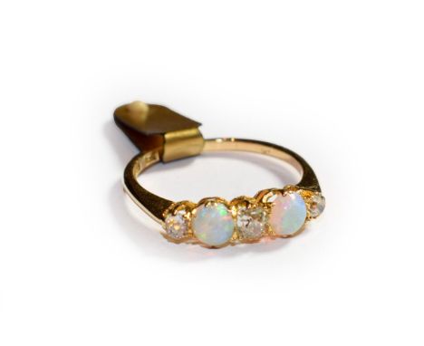 An opal and diamond five stone ring, three old cut diamonds alternate with two round cabochon opals in yellow claw settings t