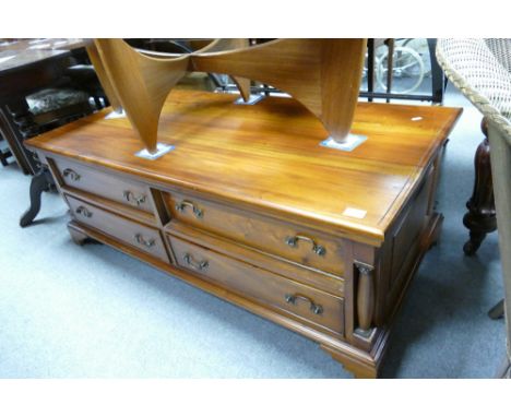 A reproduction coffee table with four drawers with column edge detail on bracket feet. 