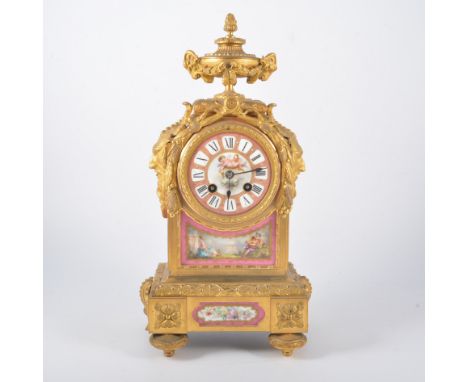 19th Century French ormolu mantel clock, the case with an urn finial and mask heads, Sevres style painted porcelain panels, F