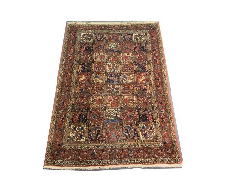 A Persian Baktiar Carpet, red ground and bordered  Khesti (garden motif design) with the carpet divided up into rectangles of