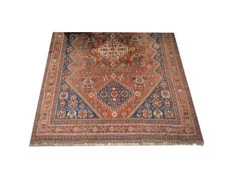 Persian pattern carpet, three lozenge medallions on a red ground, blue spandrels, multiple borders, approximately 290cm x 212