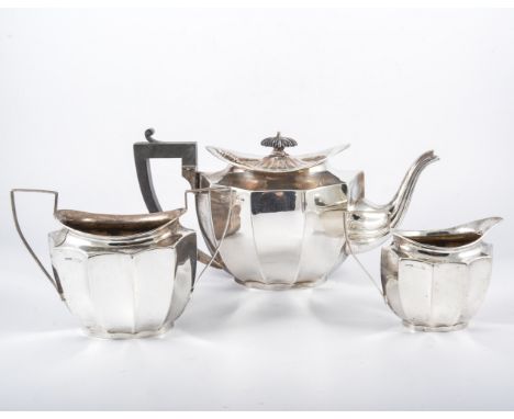 A silver three piece tea set, by F H Adams & Co, Birmingham 1923, fluted form, the teapot with ebonised handle and finial, 16