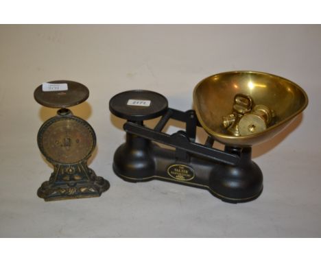 Pair of black Salter kitchen scales with small set of brass bell form weights, and another brass Salter scale