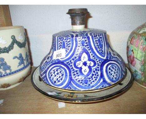 Three North African pottery dishes decorated with Arabic script together with a similar blue and white lid / candlestick base